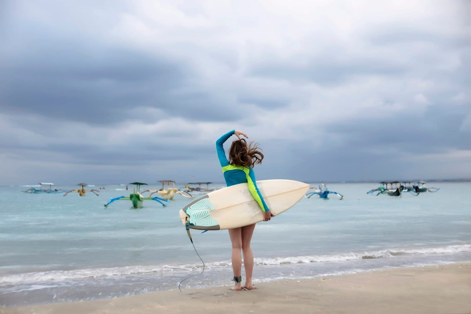 Indonesia, Bali, young woman with surf board