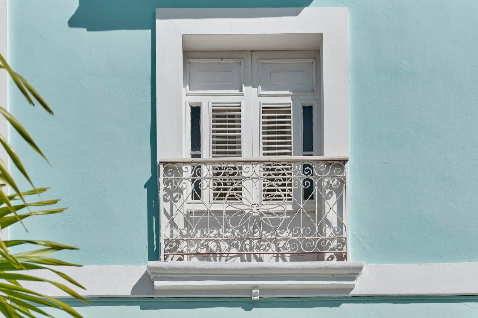 Window with small French balcony in neoclassical building in historic center of Cienfuegos, Cuba.
