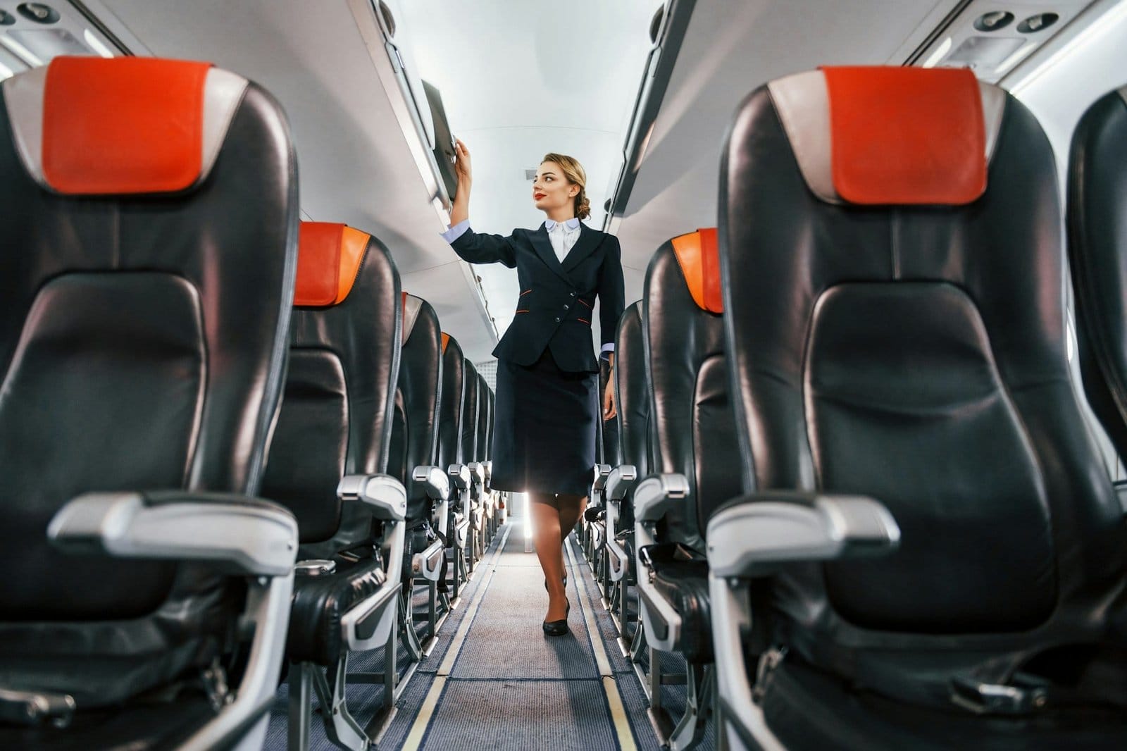 Empty seats. Young stewardess on the work in the passanger airplane
