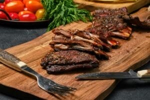 Grilled lamb breast ribs on wooden cutting board