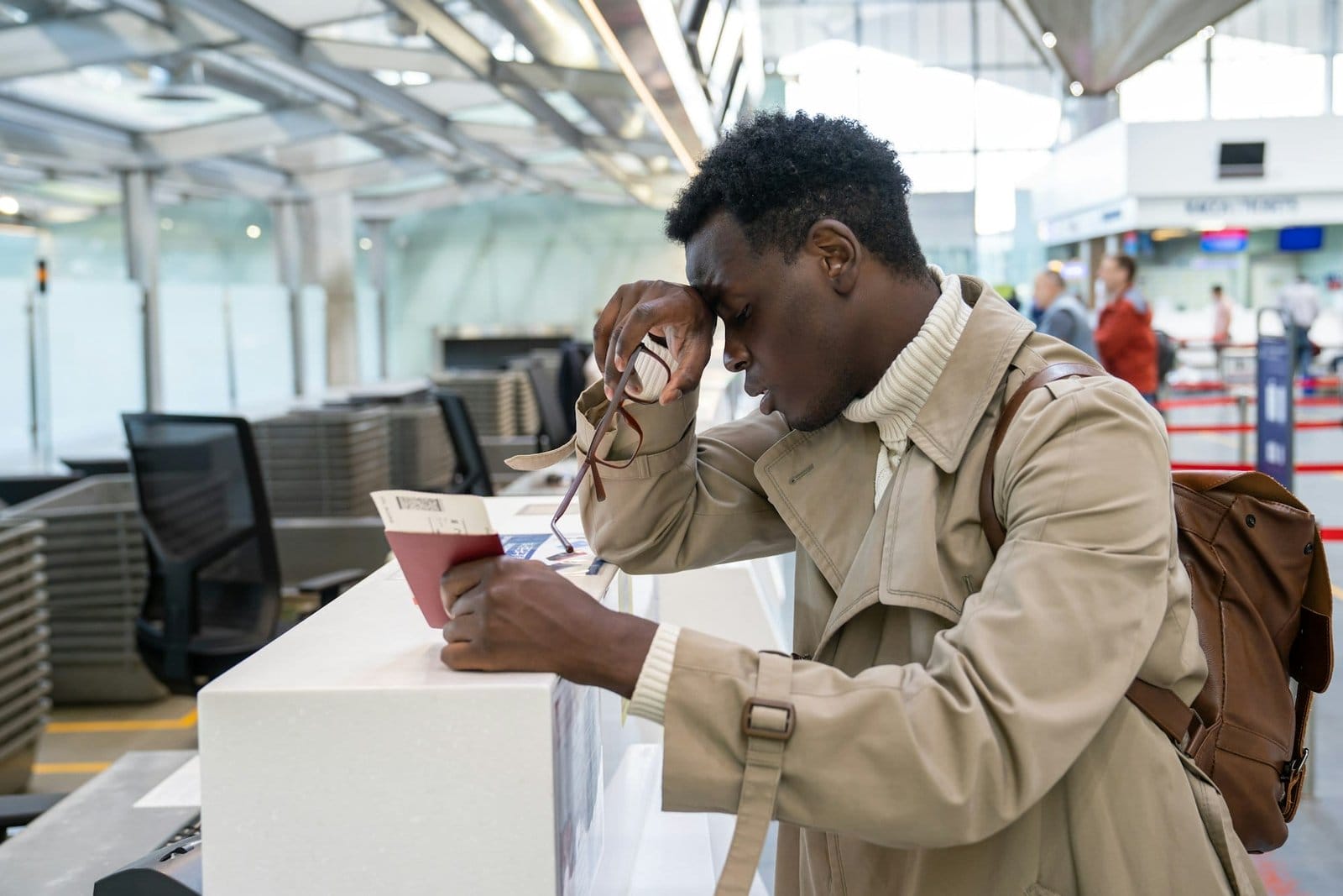 Black man upset about the cancellation flight, missed the plane, standing at check-in counter