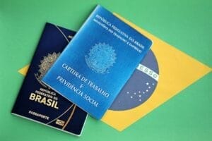 Passport of Brazil and work card with brazilian reais money bills on flag background