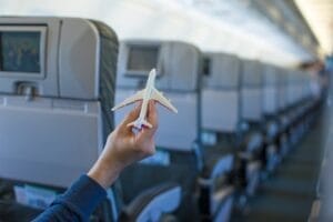 Close up hand holding an airplane model inside a large aircraft