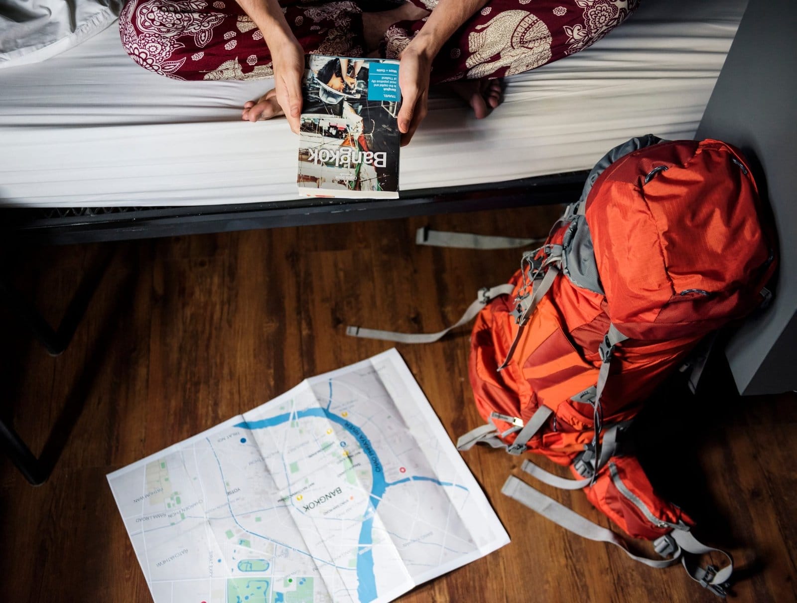 Hands holding Bangkok Thailand travel guide book with map on the