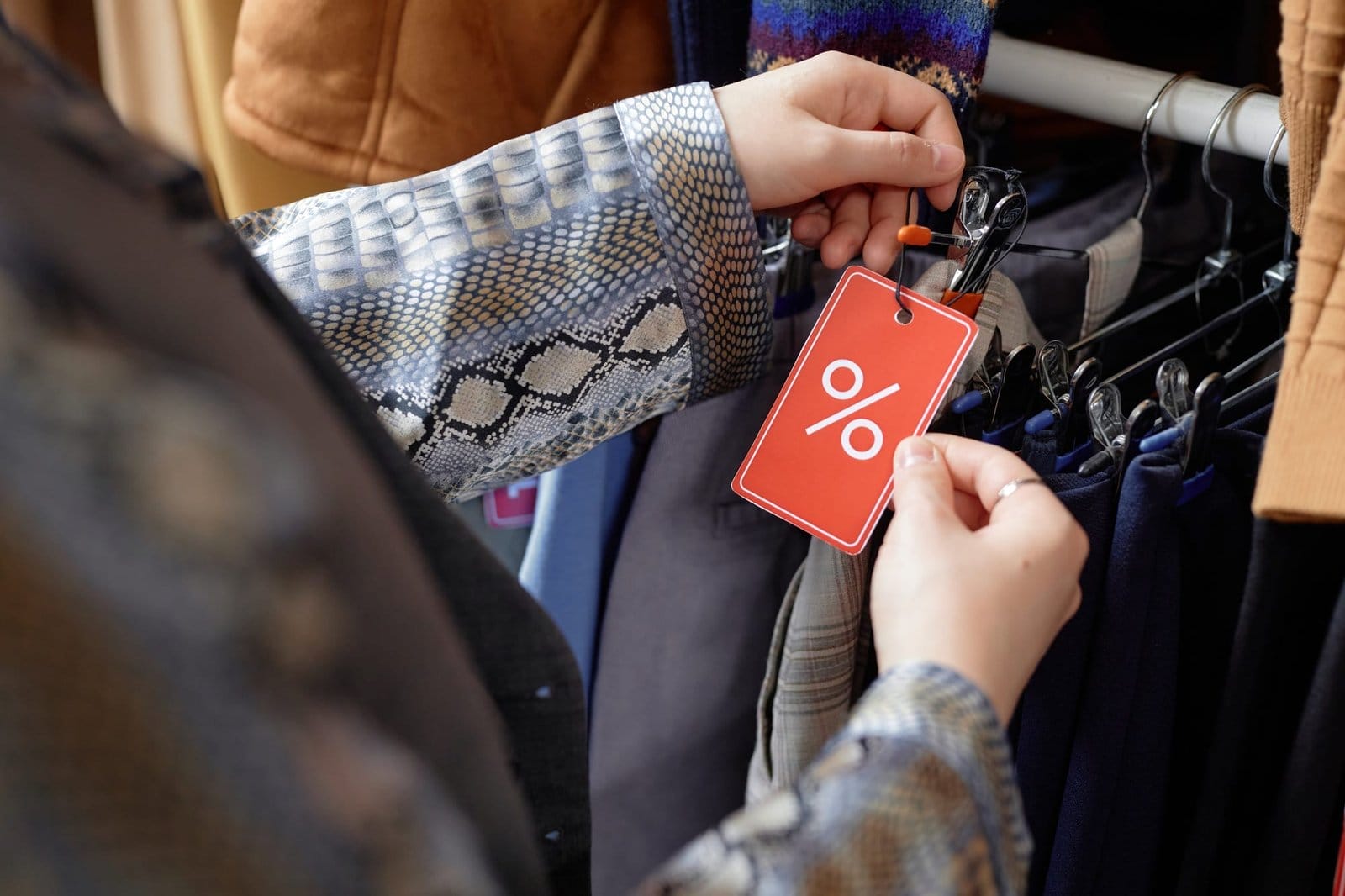 Hands of Shopper Choosing Clothes at Discounted Price
