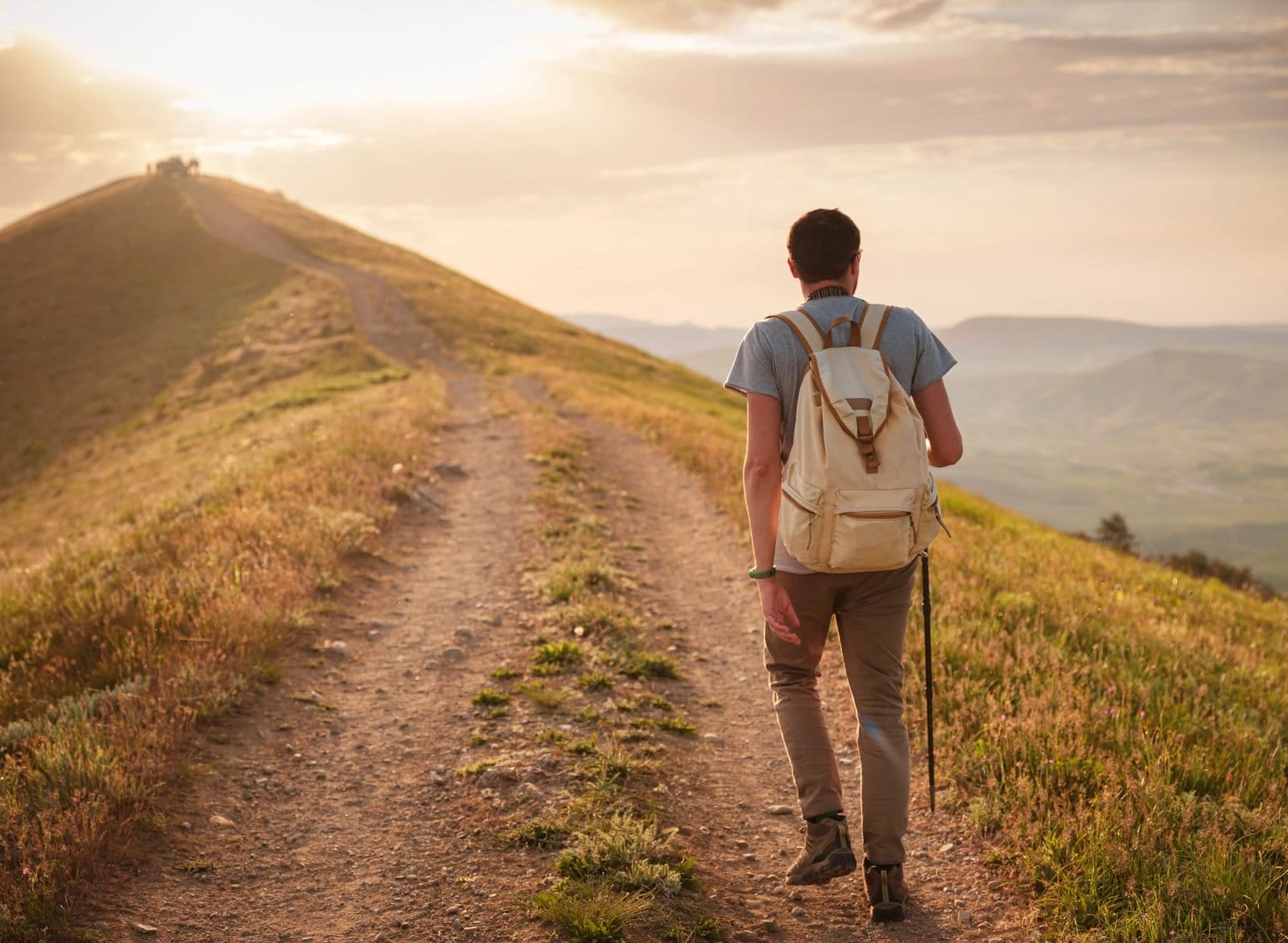 Young man travels alone on the backdrop of the mountains