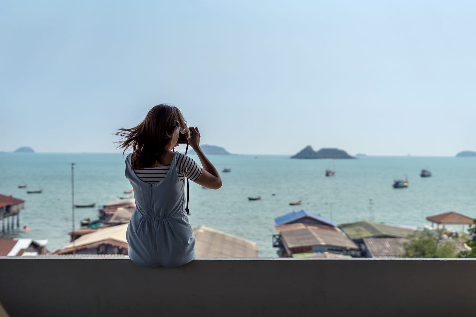 Young woman traveler sitting and take a photograph
