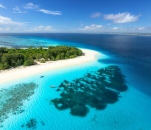Aerial view of blue sea and Mnemba island, Zanzibar. Top view