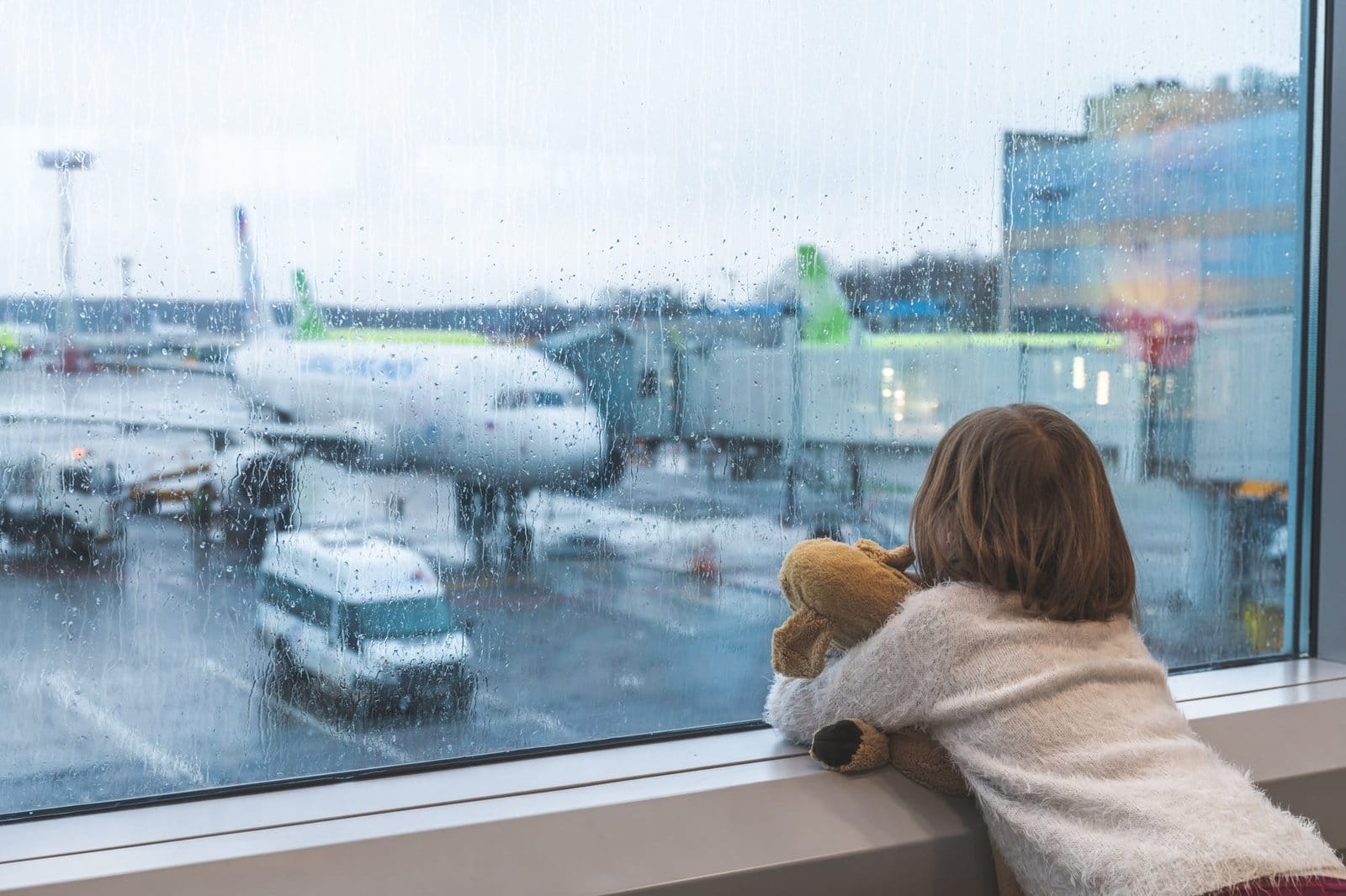 airport, airplanes, cars through glass with rain