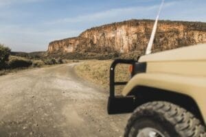 Safari in Hell's Gate national park in Kenya. Off road jeep car, savannah and mountain view