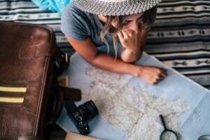 Woman at home planning travel vacation looking the guide map and smile - happy wanderlust