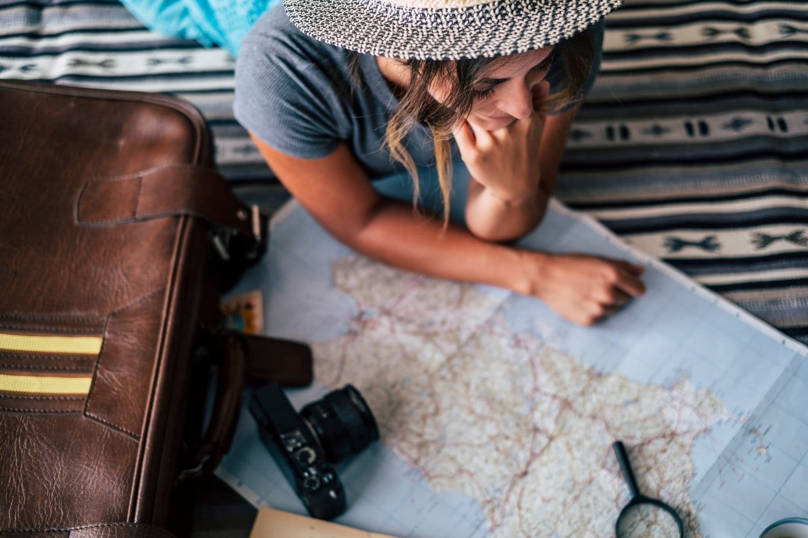 Woman at home planning travel vacation looking the guide map and smile - happy wanderlust