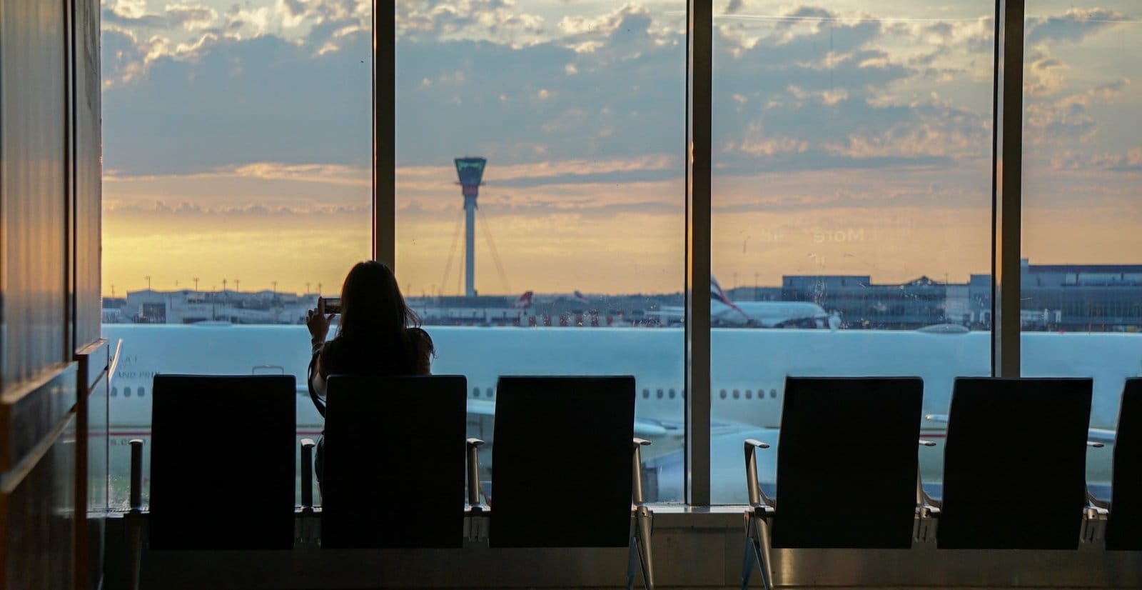 Woman taking photos in airport. Traveling. Travel. Vacations. Airports. Waiting. Seating.