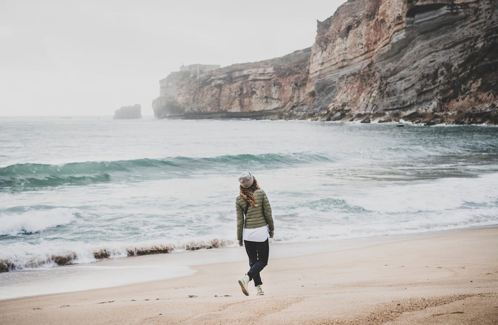 Woman walking at Atlantic ocean beach in Portugal