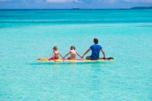 Father and kids on surfboard during summer vacation