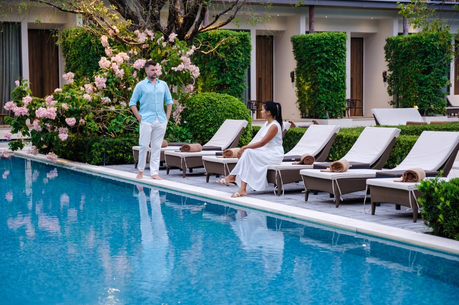 Luxury 5 star hotel pool in Asia A couple of men and women on vacation at a luxury hotel resort,