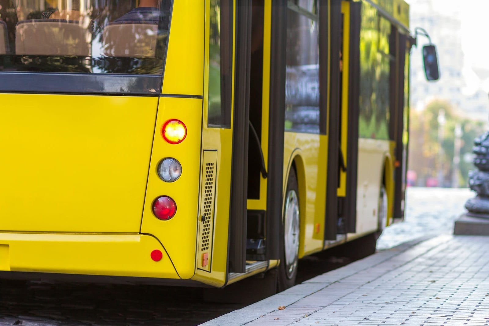 Modern yellow city bus with open doors at bus station