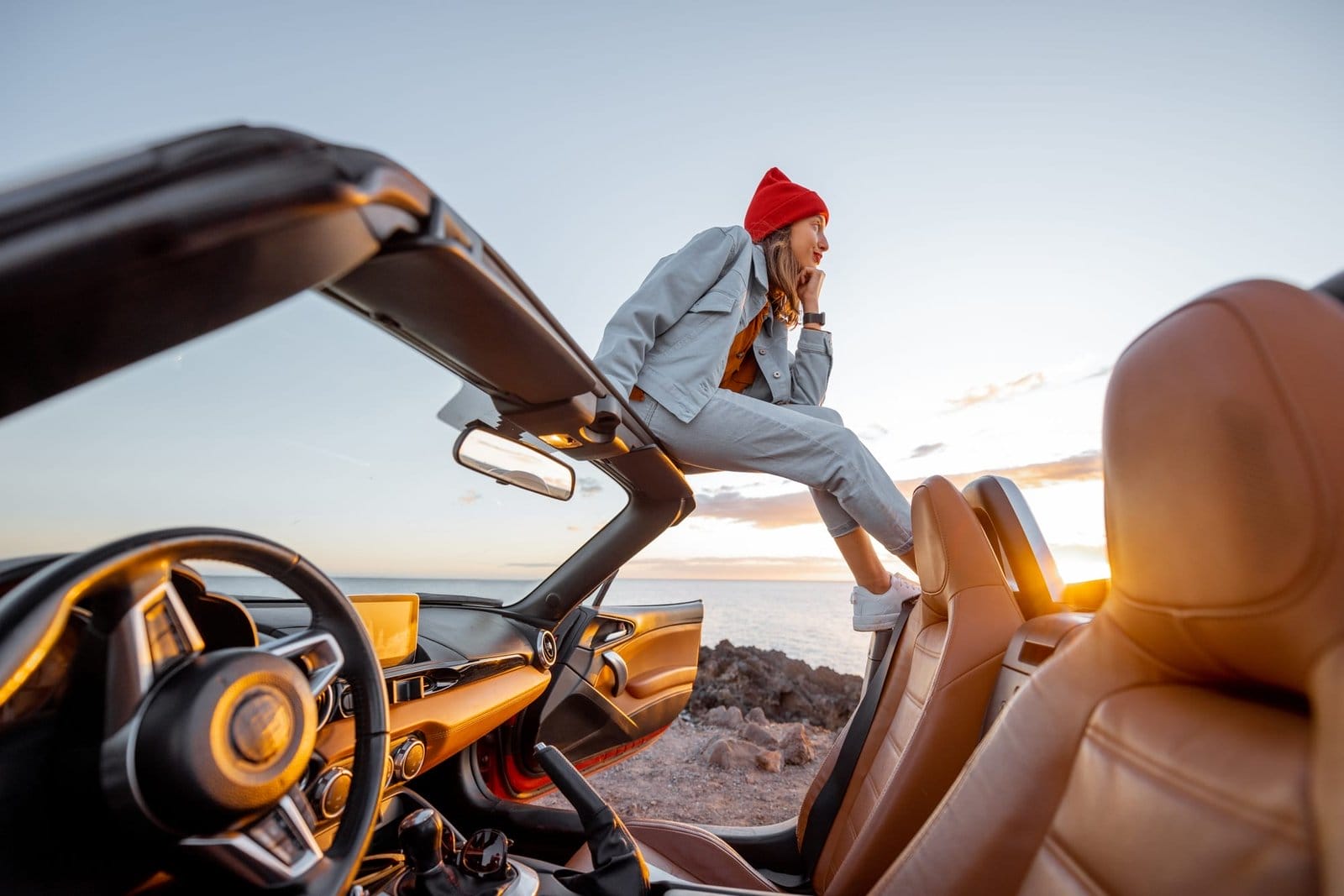 Woman traveling by car on the rocky ocean coast
