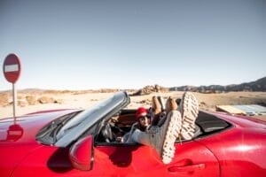Woman traveling on converrtible sports car