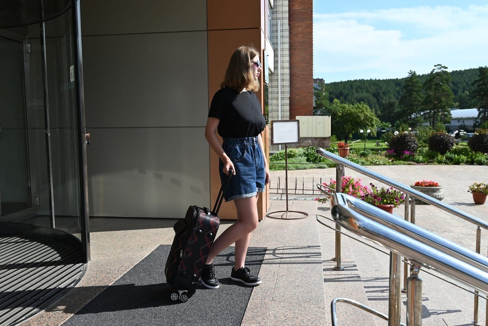 An elegant girl with luggage in the lobby the hotel. A woman with a suitcase on vacation or traveli