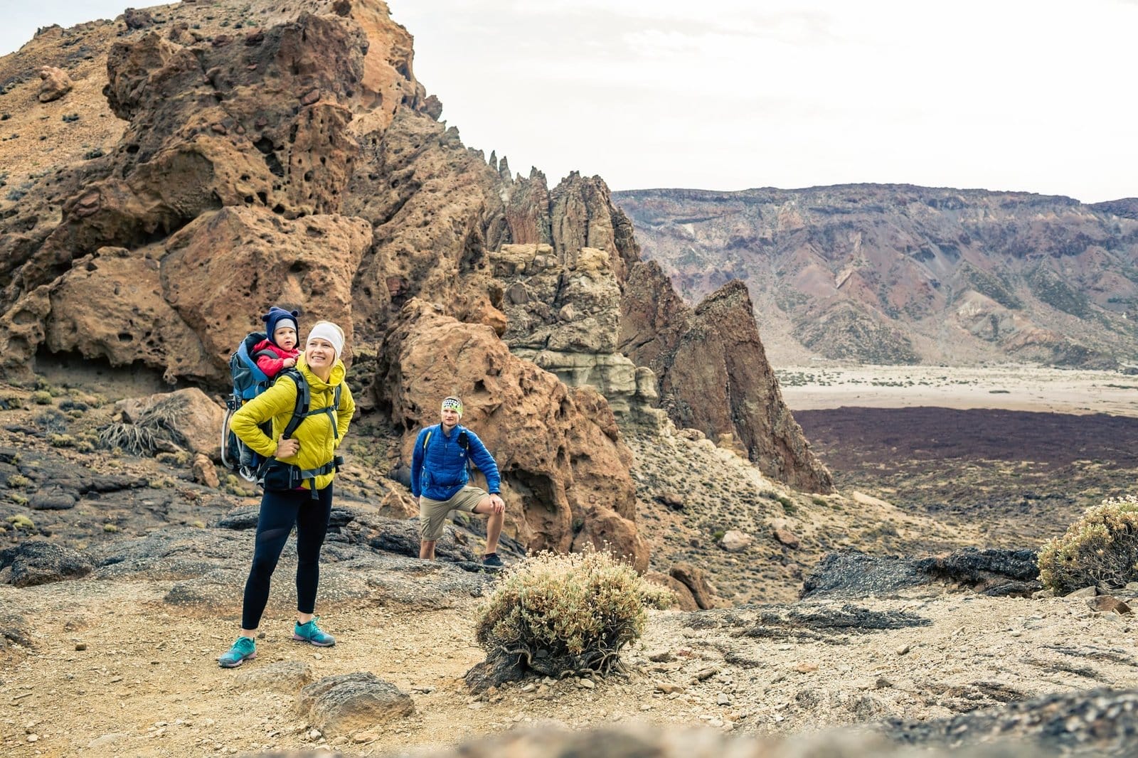 Family hiking with baby boy travelling in backpack