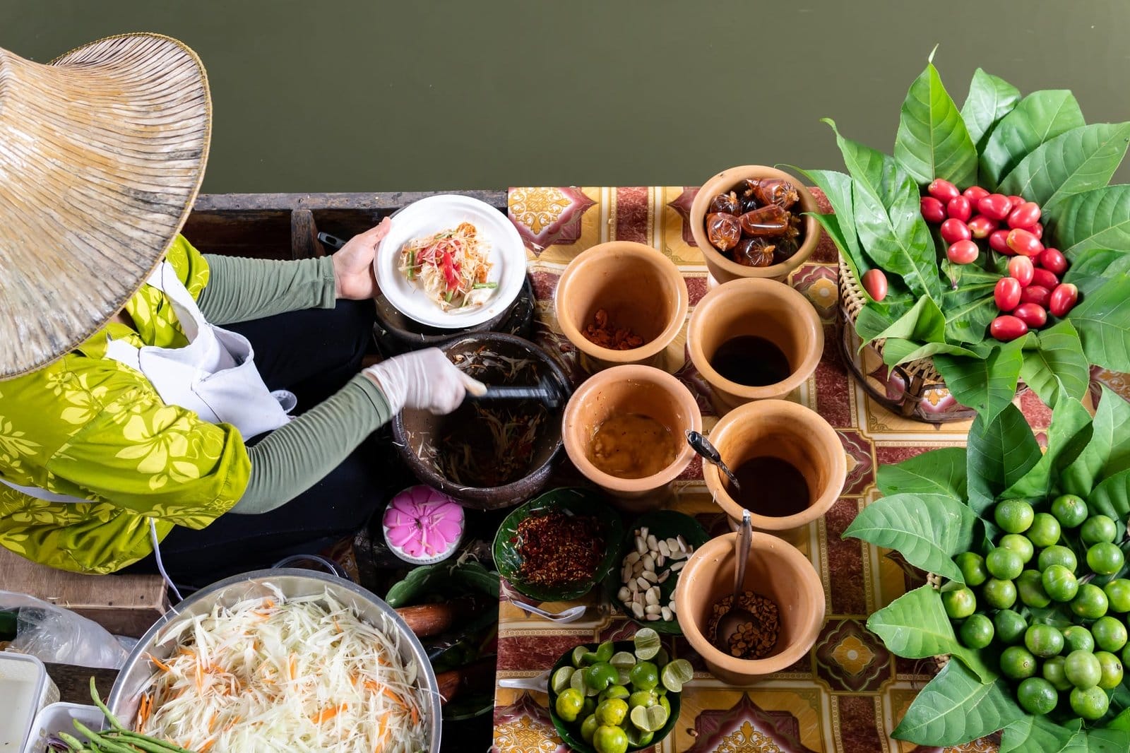 Market woman in boat cooking food at floating Market in Bangkok, Thailand