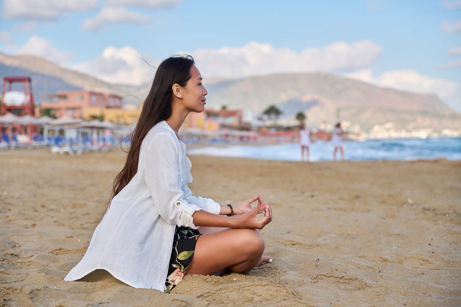 Young woman practicing yoga on the beach