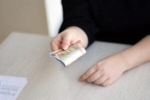 Brazilian money bills in woman hand. Female gives bunch of brazilian reais to us