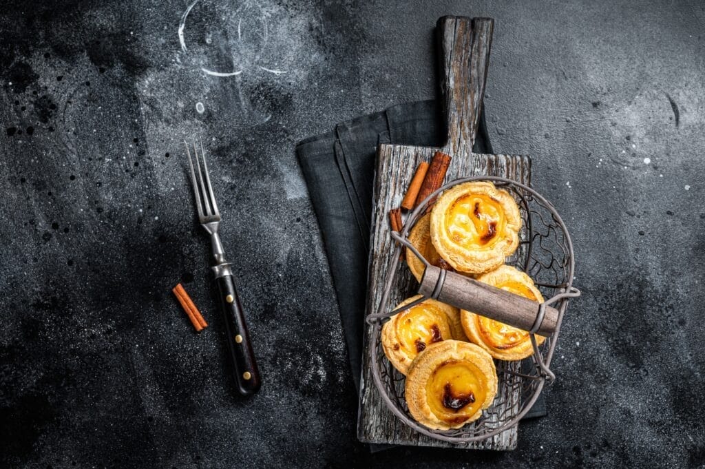Traditional Lisbon Pasteis de nata in a basket. Black background. Top view